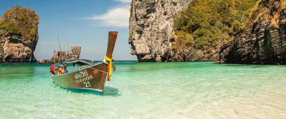 Long boat on a beach in Thailand with crystal clear waters